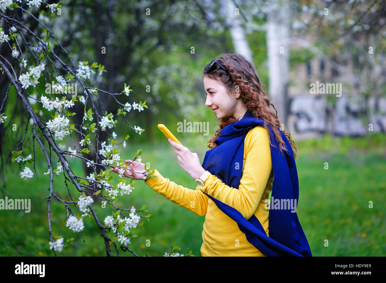 Belle jeune femme marche dans le parc avec votre téléphone Banque D'Images