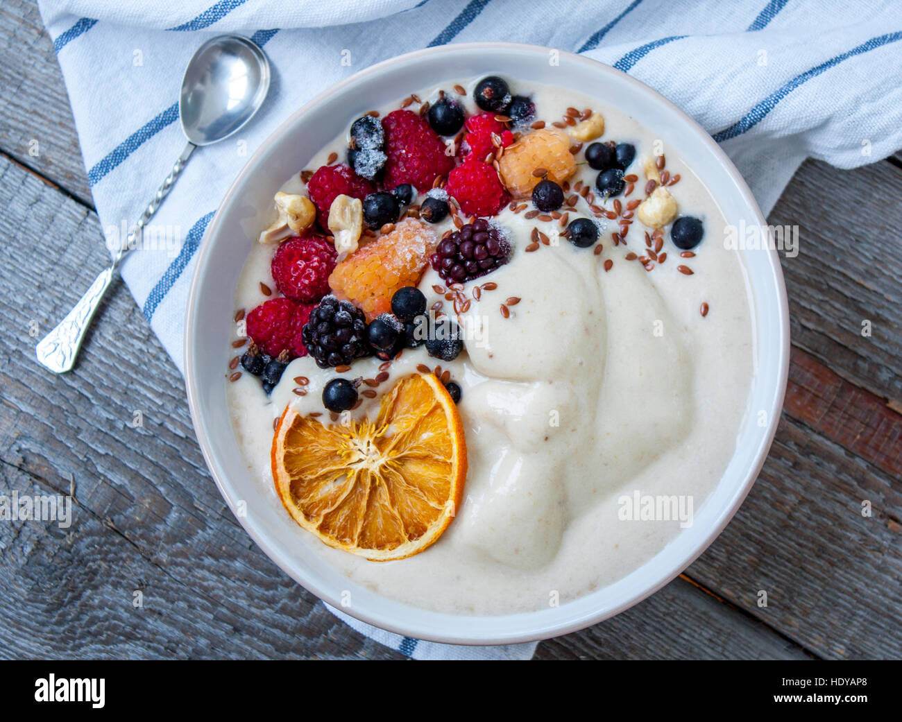 Bol à smoothie banane, la crème glacée aux fruits rouges, les noix, le lin. Parfait pour le régime de detox ou simplement un repas sain. L'amour pour la santé de l'aliment cru concept. Banque D'Images