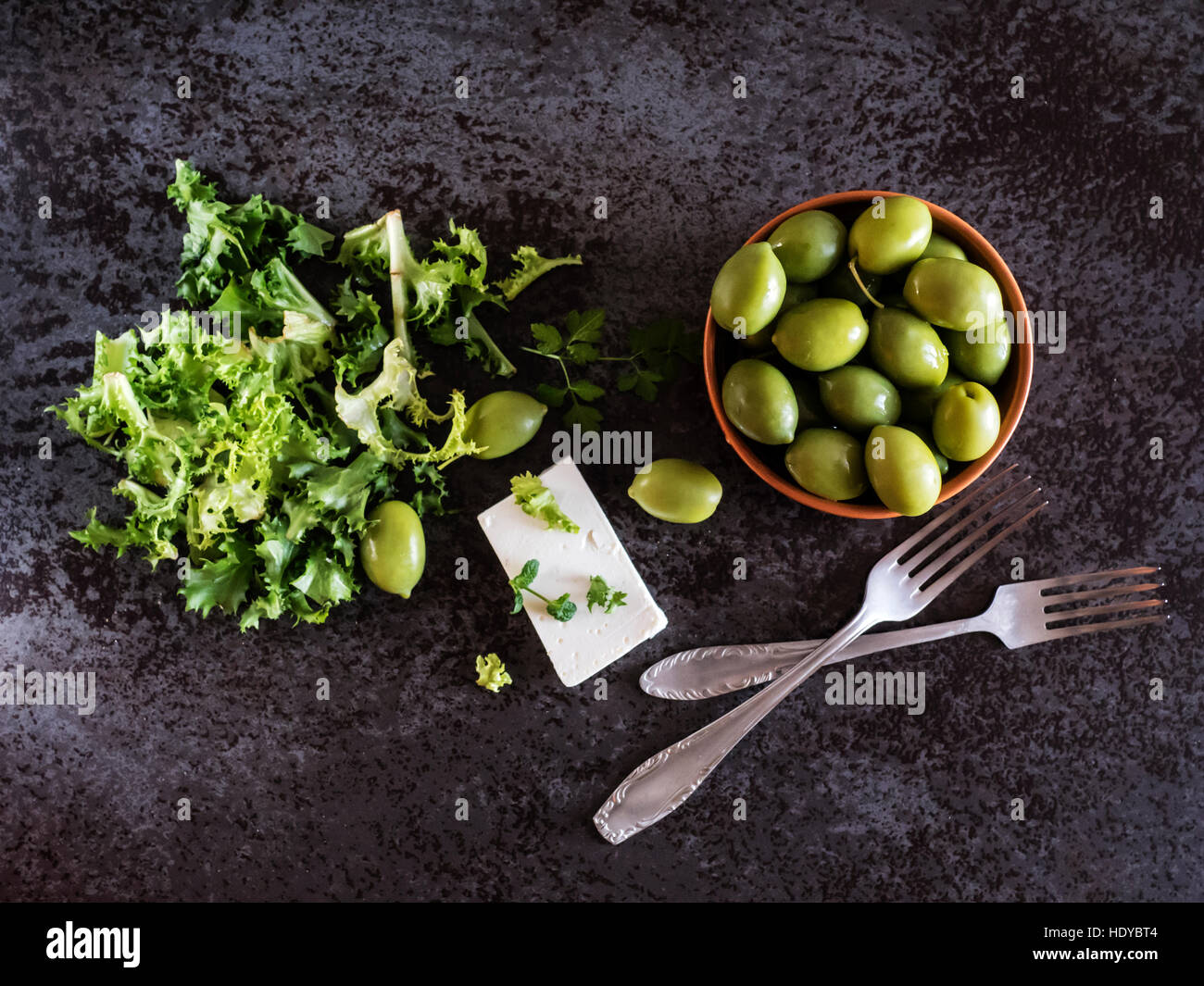 Le fromage Feta aux olives et d'herbes vertes sur fond de marbre gris. Selective focus Banque D'Images