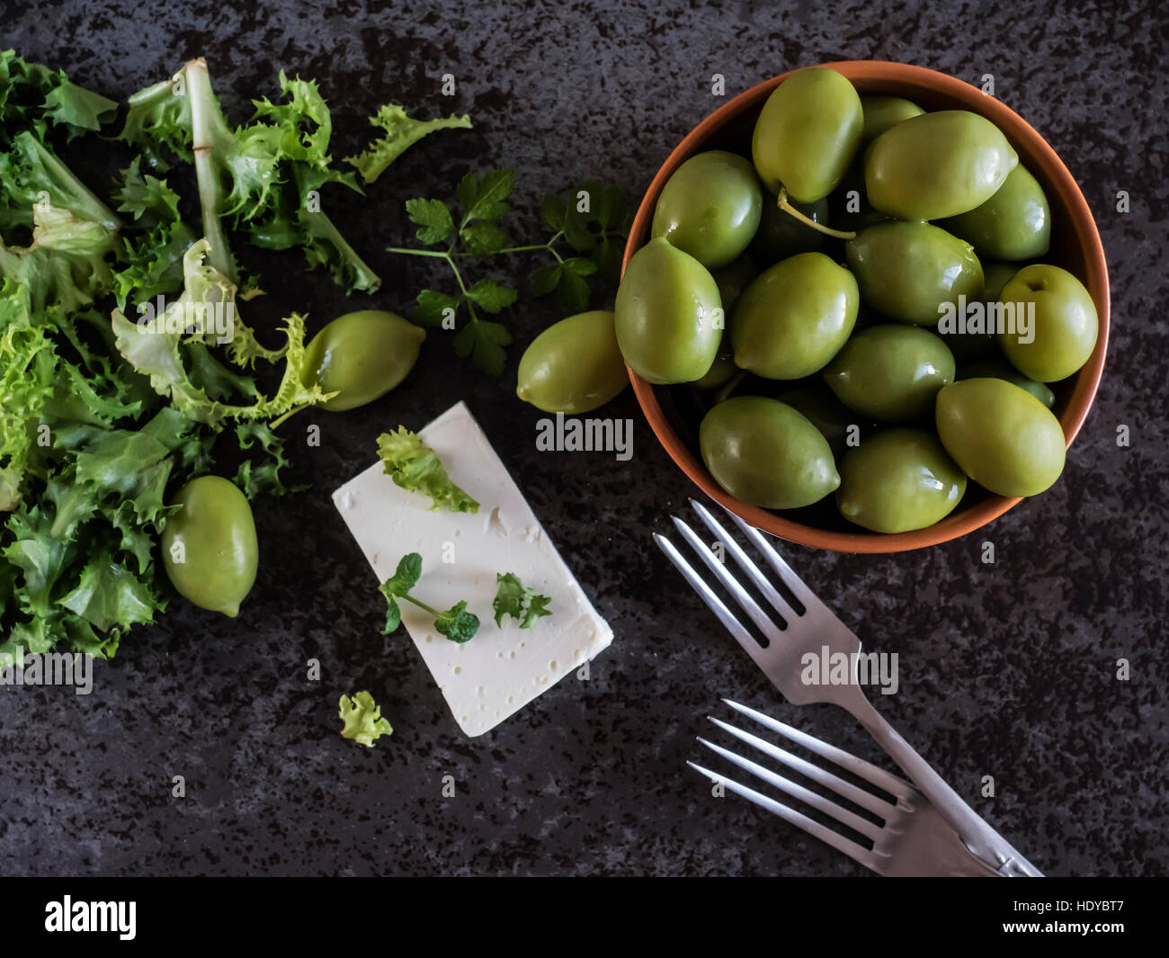 Le fromage Feta aux olives et d'herbes vertes sur fond de marbre gris. Selective focus Banque D'Images