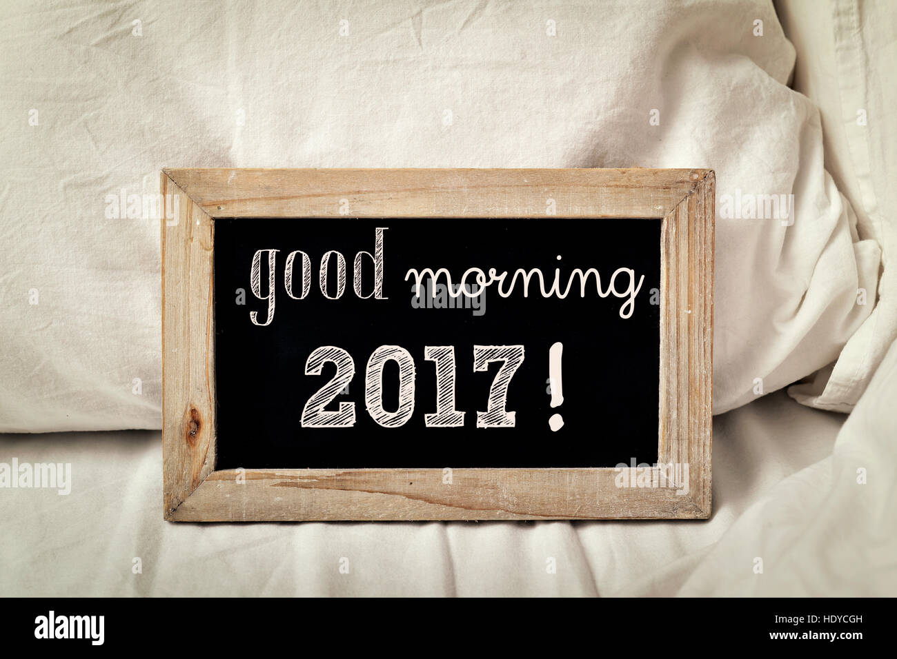 Un tableau en bois avec le texte écrit en 2017 bonjour, placé sur un lit avec des draps blancs Banque D'Images