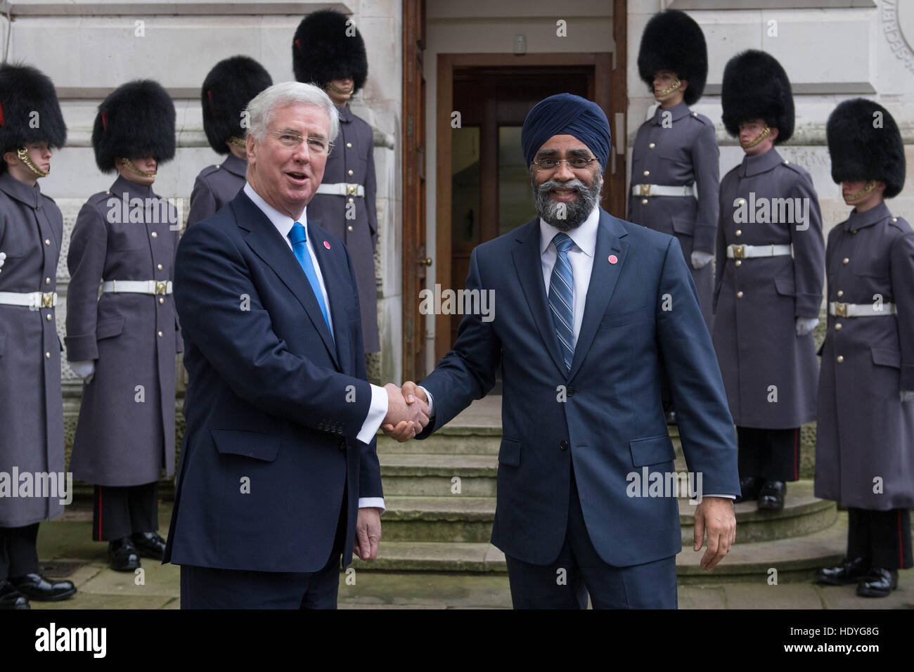 Le Secrétaire à la défense, Sir Michael Fallon (à gauche) accueille le ministre canadien de la Défense Harjit Sajjan en dehors de l'Office des étrangers avant d'un sommet à Londres avec les ministres de la défense de la coalition des pays qui se battent, est également connu comme Daesh, en Iraq et en Syrie. Banque D'Images