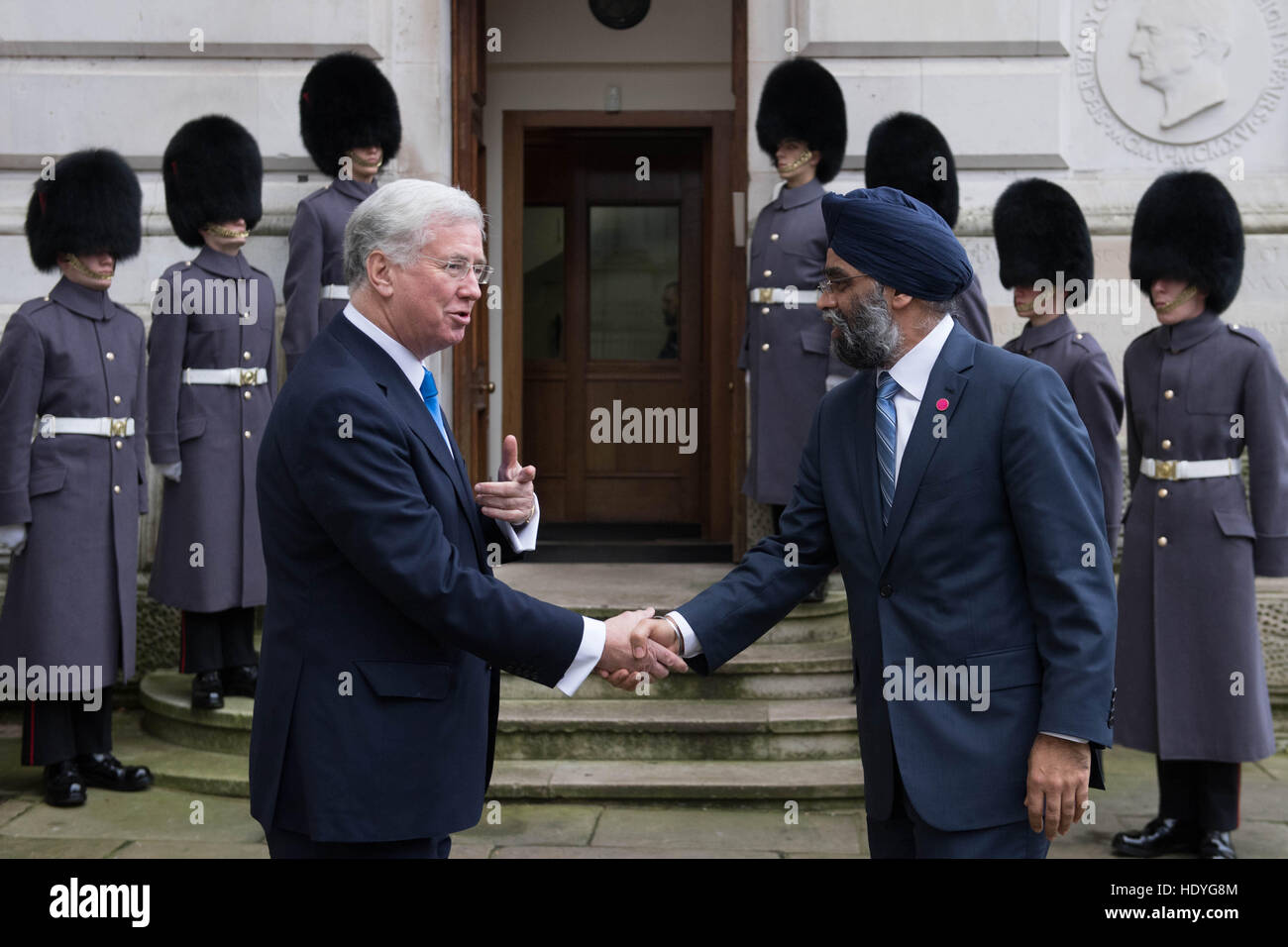 Le Secrétaire à la défense, Sir Michael Fallon (à gauche) accueille le ministre canadien de la Défense Harjit Sajjan en dehors de l'Office des étrangers avant d'un sommet à Londres avec les ministres de la défense de la coalition des pays qui se battent, est également connu comme Daesh, en Iraq et en Syrie. Banque D'Images