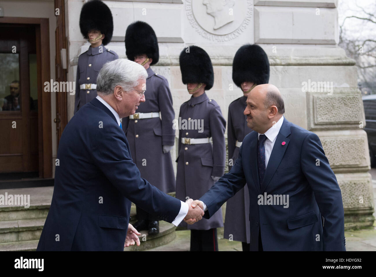 Le Secrétaire à la défense, Sir Michael Fallon (à gauche) accueille le ministre turc de la Défense Fikri Isik à l'extérieur de l'Office des étrangers avant d'un sommet à Londres avec les ministres de la défense de la coalition des pays qui se battent, est également connu comme Daesh, en Iraq et en Syrie. Banque D'Images