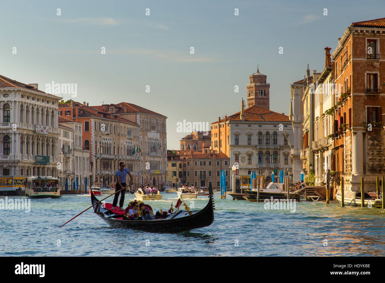 Gondole de Venise sur le Grand Canal dans la soirée du soleil sur l'eau, gondolier et passagers. Banque D'Images