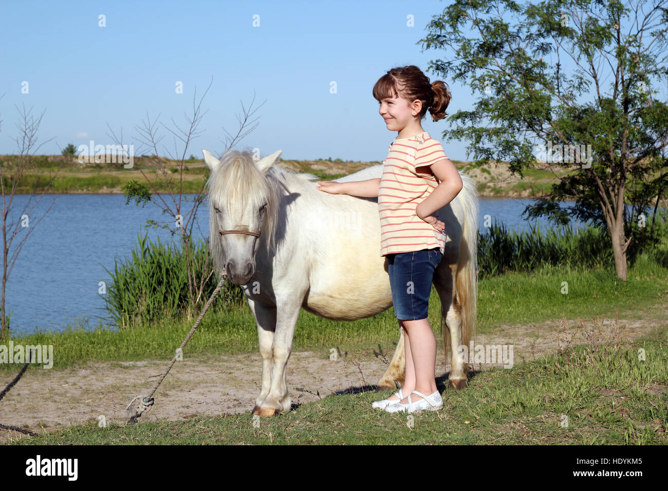 Happy little girl avec pony horse Banque D'Images