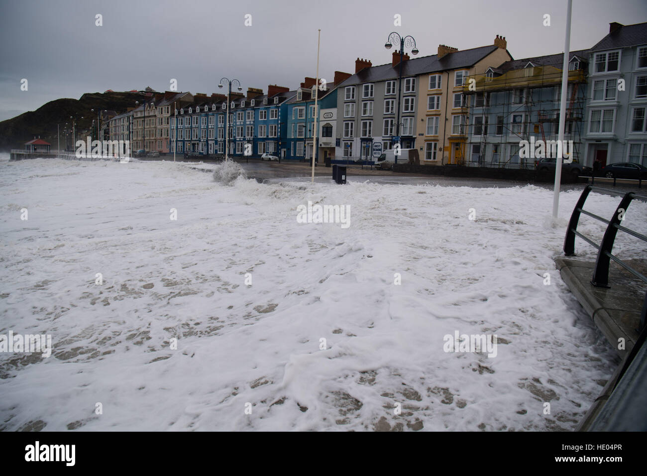 Aberystwyth, Pays de Galles, Royaume-Uni. 16 décembre 2016. Météo France : Malgré le peu ou pas de vent, une tempête sur la mer, combinée avec une très haute marée, amener d'énormes vagues de battre le front de mer à Aberystwyth, et laissant une traînée de sable et de pierres sur la promenade maritime et routier Terrasse. Photo © Keith Morris/Alamy Live News Banque D'Images