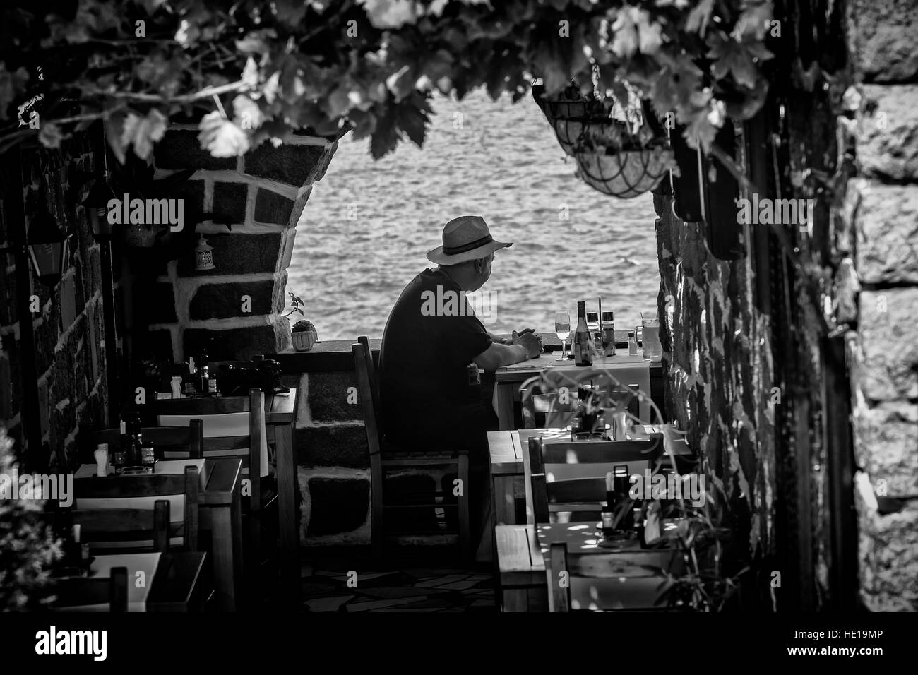 La silhouette d'un homme assis dans un restaurant en bord de mer Banque D'Images