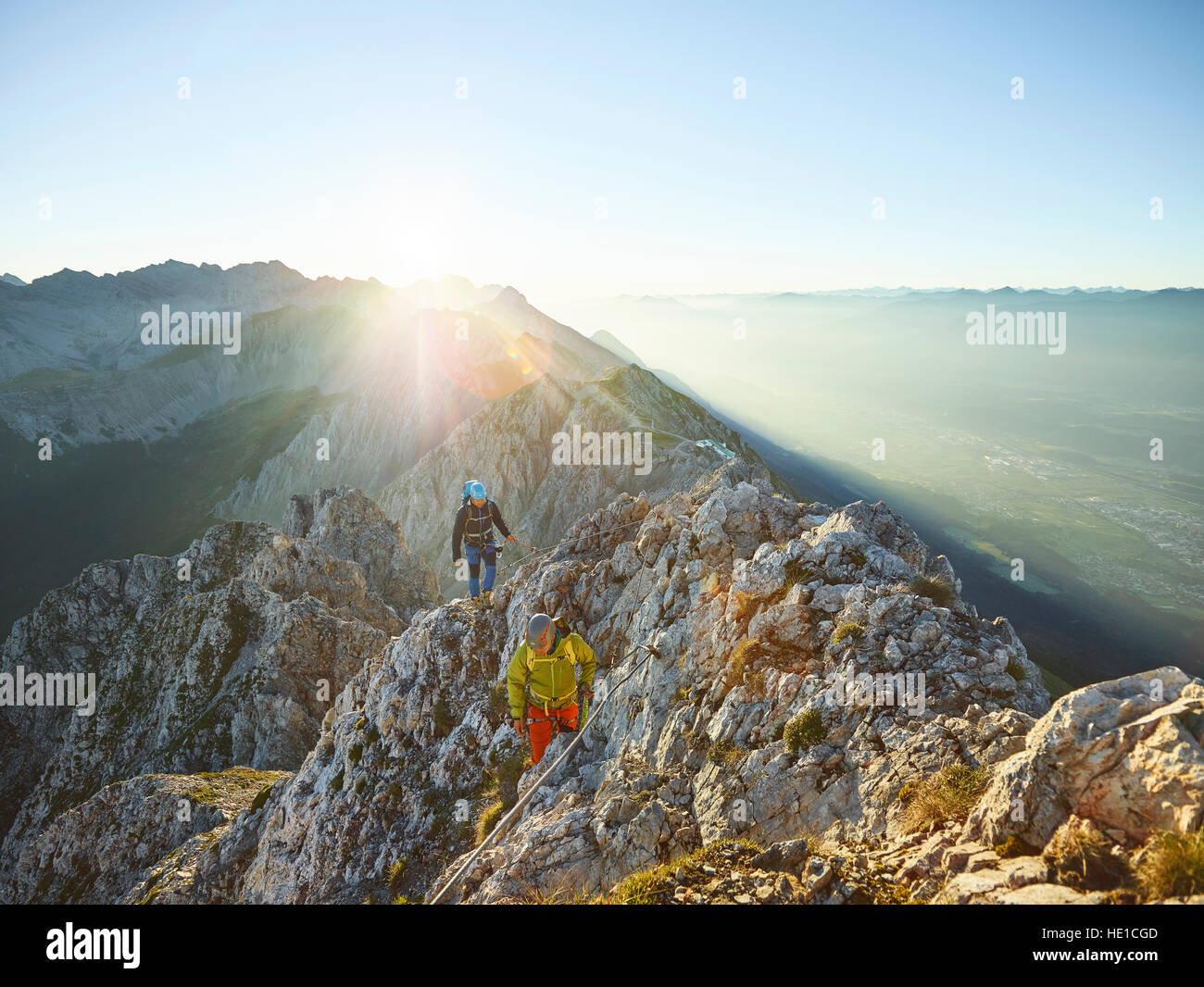 Lever du soleil sur l'arête, via ferrata, deux alpinistes attachés à un câble en acier, Nordkette Innsbruck, Tyrol, Autriche Banque D'Images