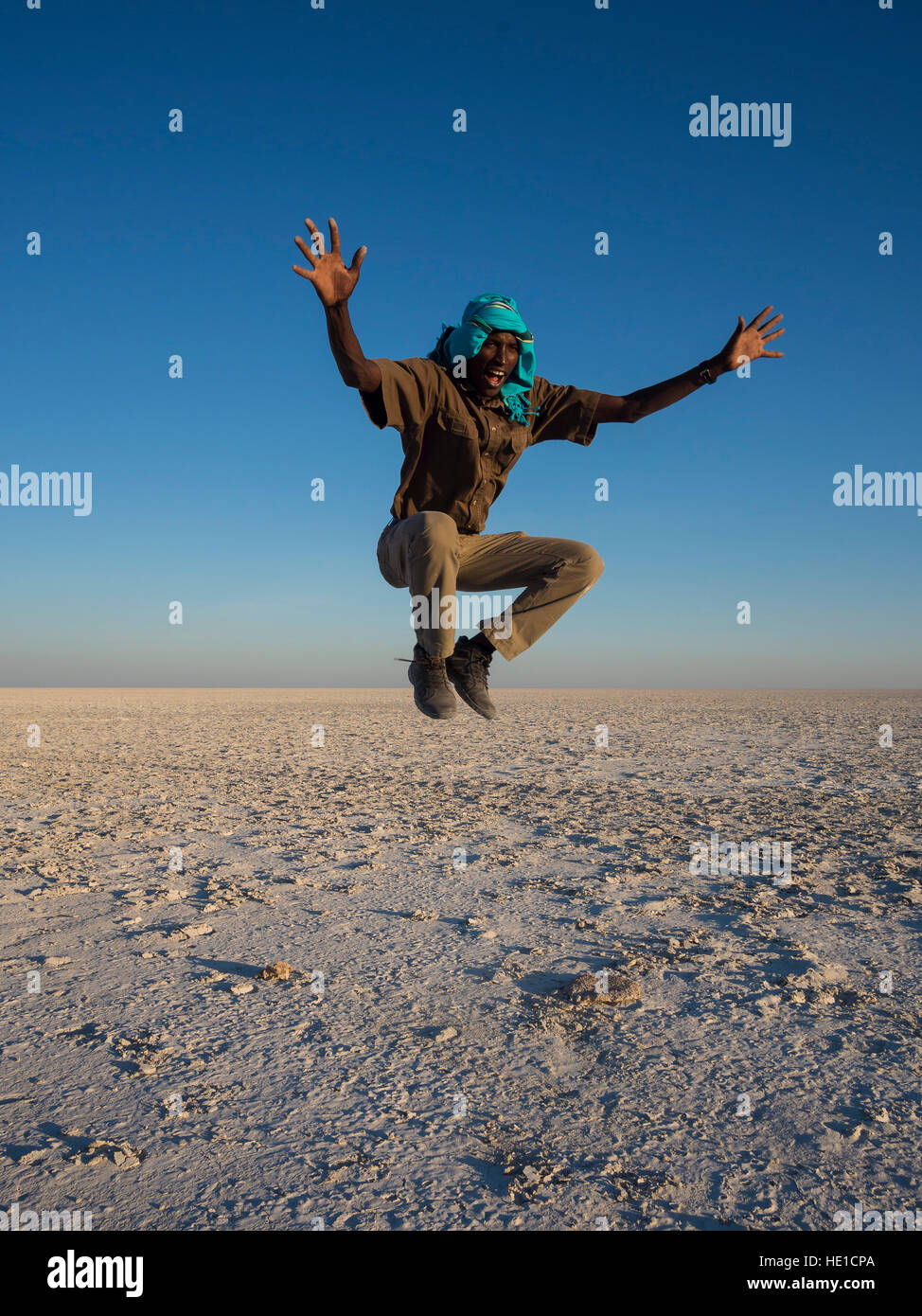 African man jumping, Makgadikgadi Pan, Botswana Banque D'Images