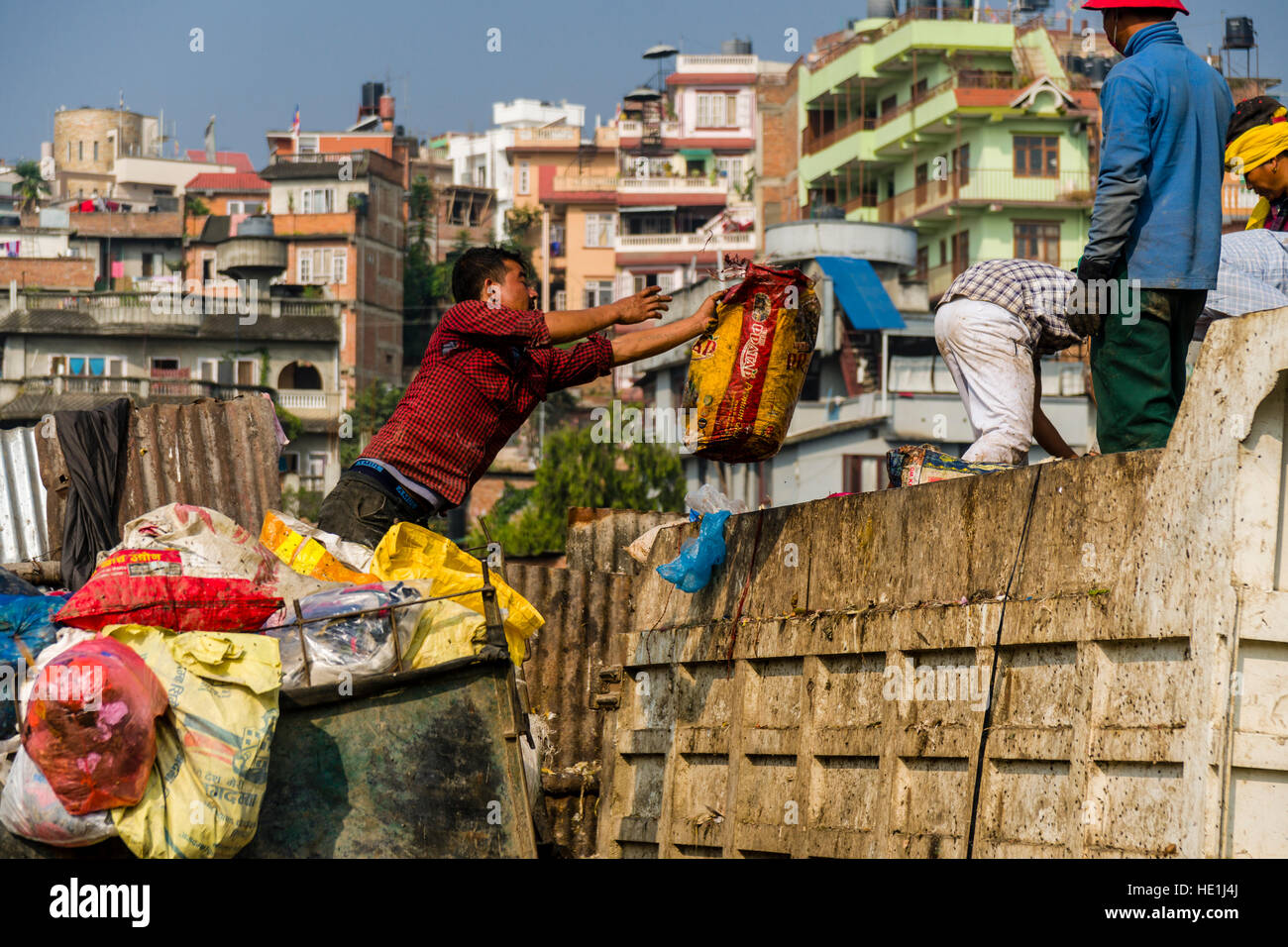 Les gens sont la collecte des ordures dans la ville, le charger sur les camions et le transporter à un dépotoir à l'extérieur de la ville Banque D'Images