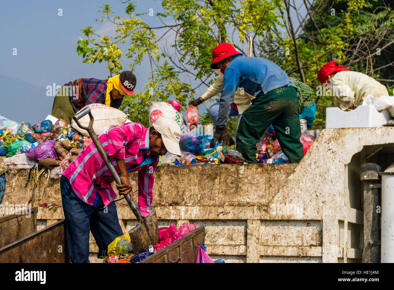 Les gens sont la collecte des ordures dans la ville, le charger sur les camions et le transporter à un dépotoir à l'extérieur de la ville Banque D'Images