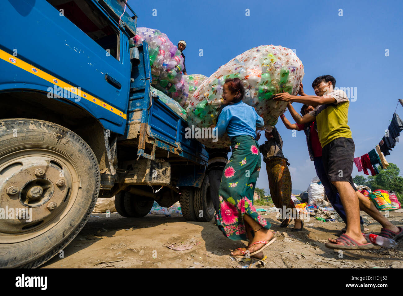 Les gens sont la collecte des bouteilles vides en plastique dans la ville, le charger sur les camions et le transporter à l'extérieur de la ville de recyclage Banque D'Images