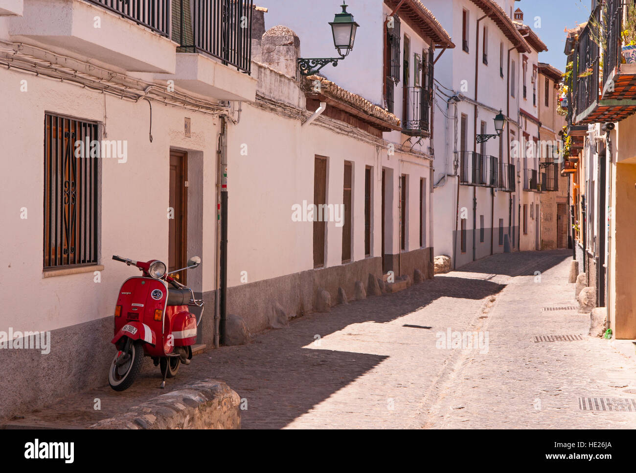 Un cyclomoteur stationné dans une étroite rue pavée, dans l'Albaicin de Grenade Espagne Banque D'Images