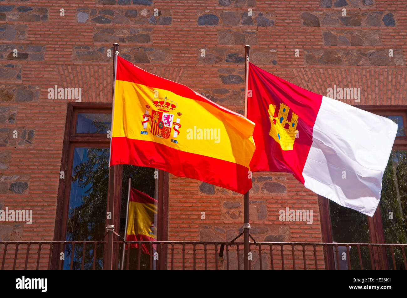Le drapeau national de l'Espagne aux côtés du drapeau régional de Castille et Mancha dans la ville fortifiée de Toledo Espagne Banque D'Images