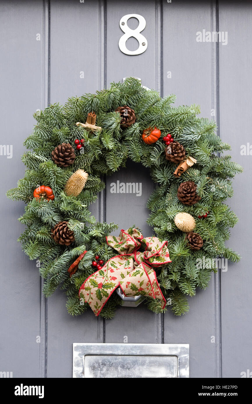 Couronne de noël décoratif suspendu par une porte avant gris. Banque D'Images