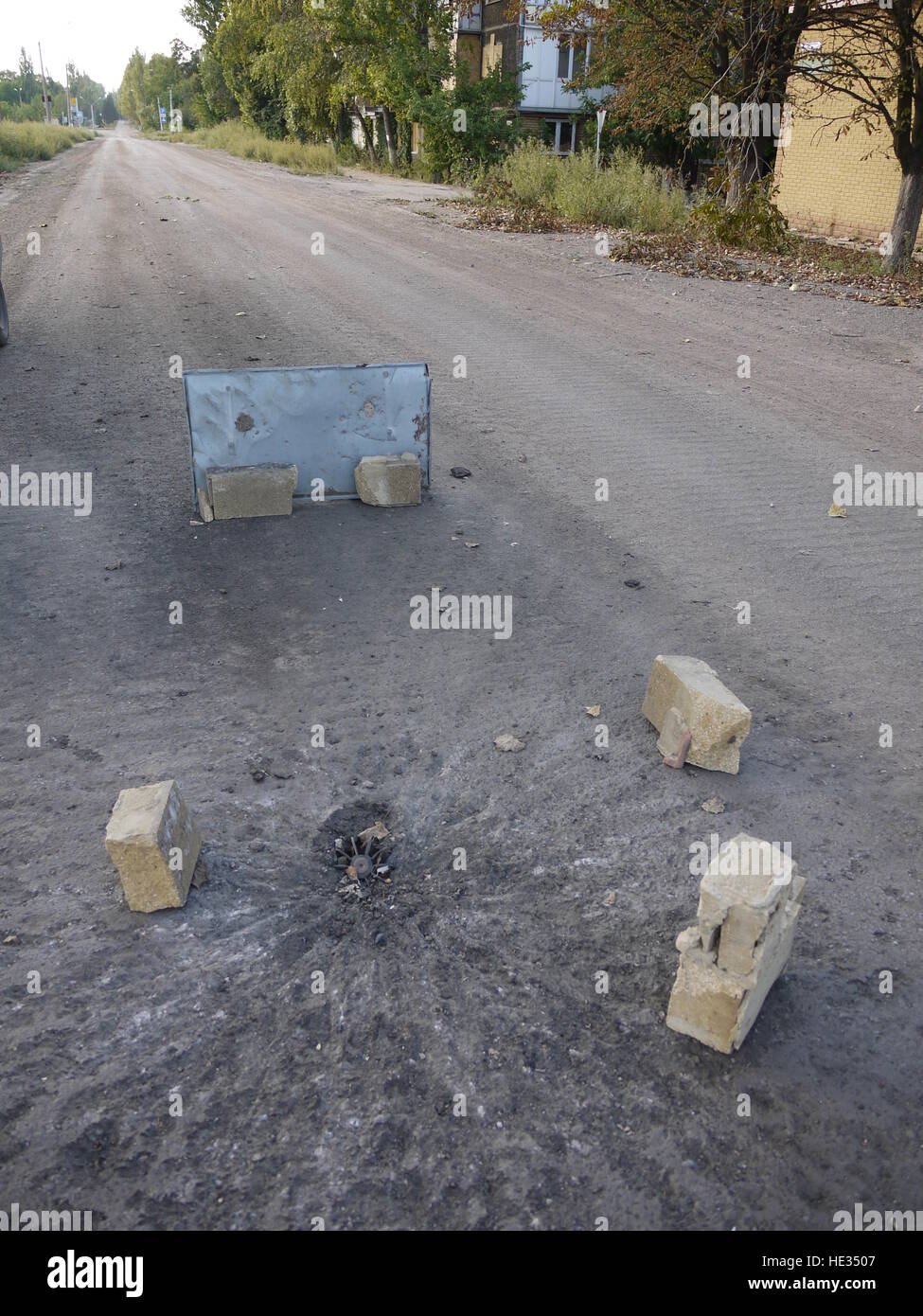 Un des obus de mortier sont tombés sur la route de l'Est de l'Ukraine et est simplement marquée par quelques pierres Banque D'Images
