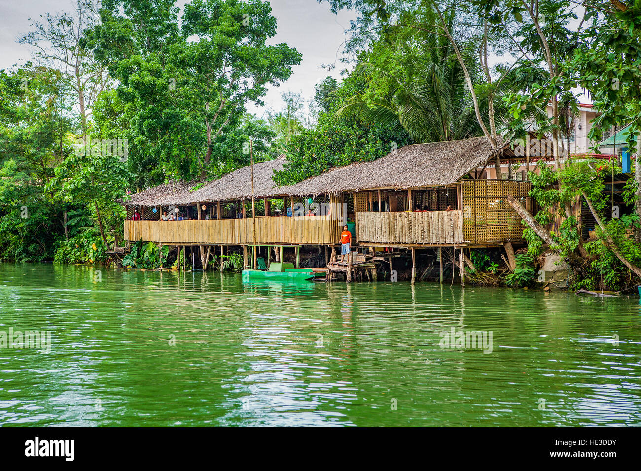 Un restaurant local construit sur pilotis se tient sur la rivière Loboc, île de Bohol, Philippines. Banque D'Images