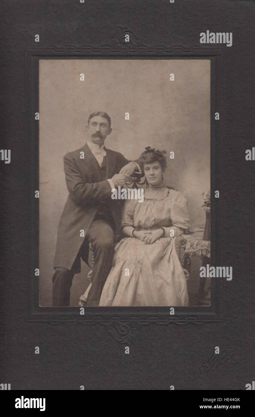 Cette photographie historique met en scène un couple non identifié du passé, capturant un moment dans le temps avec un accent sur la photographie vintage et la mode de l'époque. Banque D'Images