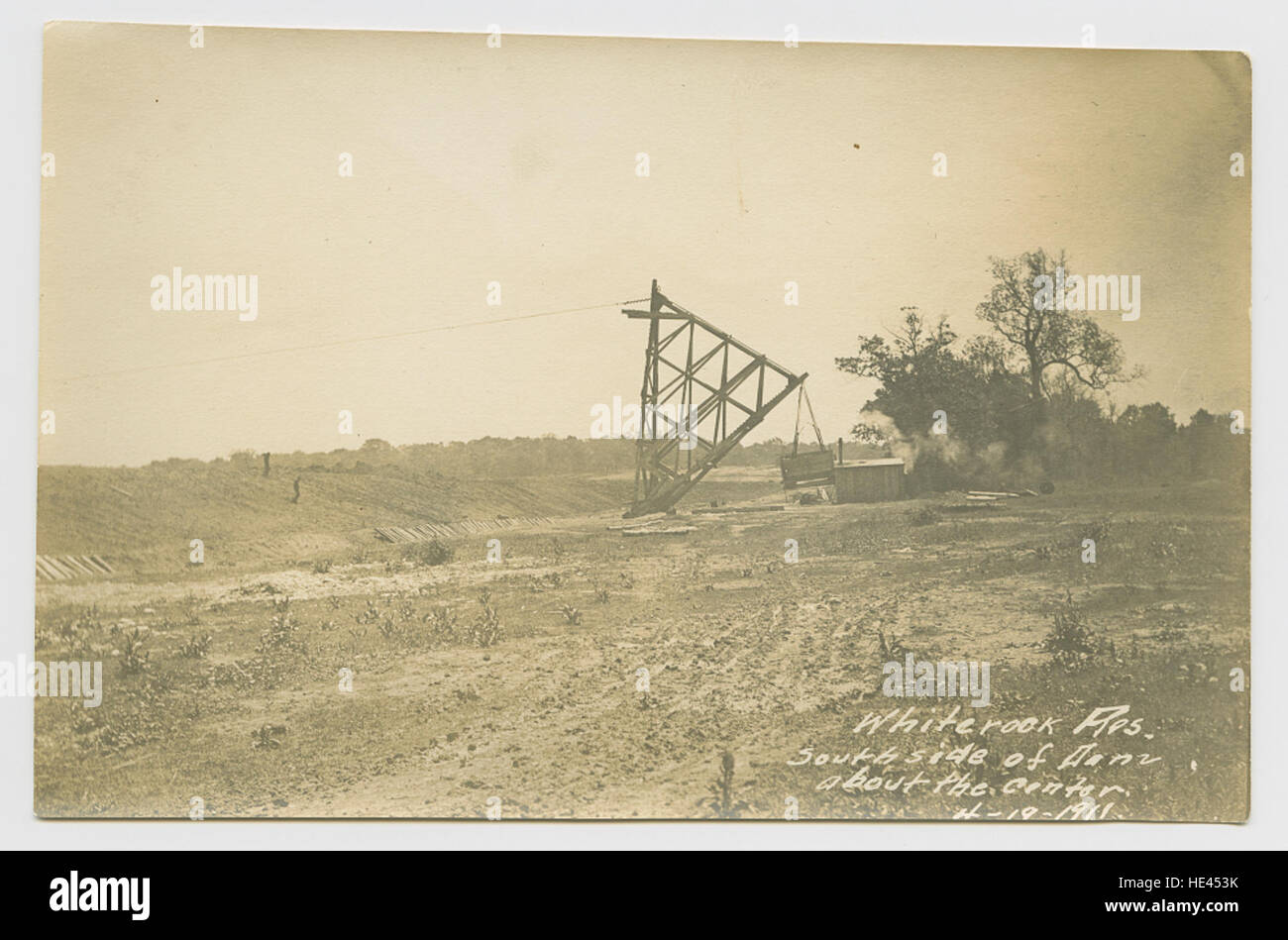 Cette image historique capture le côté sud du barrage au réservoir White Rock au Texas, mettant en valeur la merveille d'ingénierie de la structure. Le barrage, construit pour gérer l'approvisionnement en eau de la région, est depuis longtemps un élément essentiel de l'infrastructure et du système de gestion de l'eau de Dallas. Banque D'Images