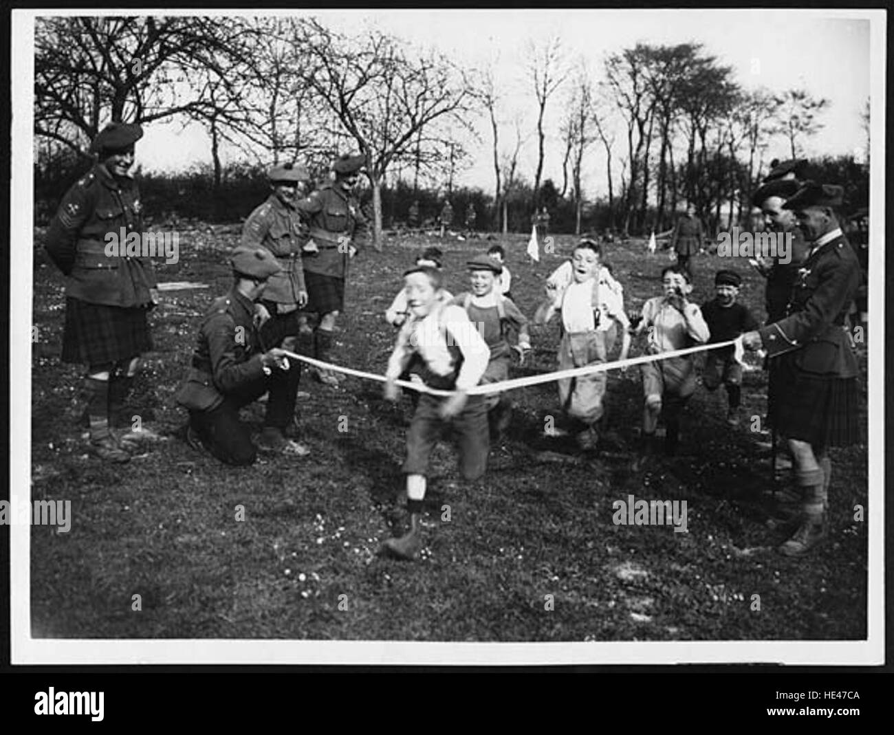 Cette image historique, mettant en vedette une course pour les enfants français, capture un moment poignant des suites de la première Guerre mondiale, connu sous le nom de « Tommy », les soldats britanniques ont aidé à apporter secours et soutien aux enfants locaux, symbolisant la solidarité pendant la reprise de la guerre. Banque D'Images