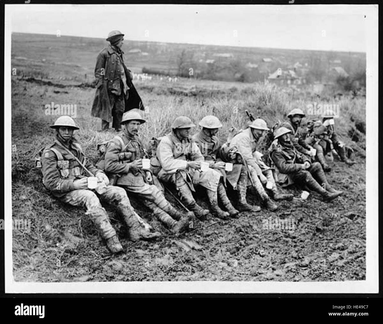Une image nostalgique montrant des officiers et des hommes recevant une boisson chaude, symbole de confort et de camaraderie lors d’un événement historique. Cette photographie représente des moments de répit dans des moments difficiles d'une époque révolue. Banque D'Images