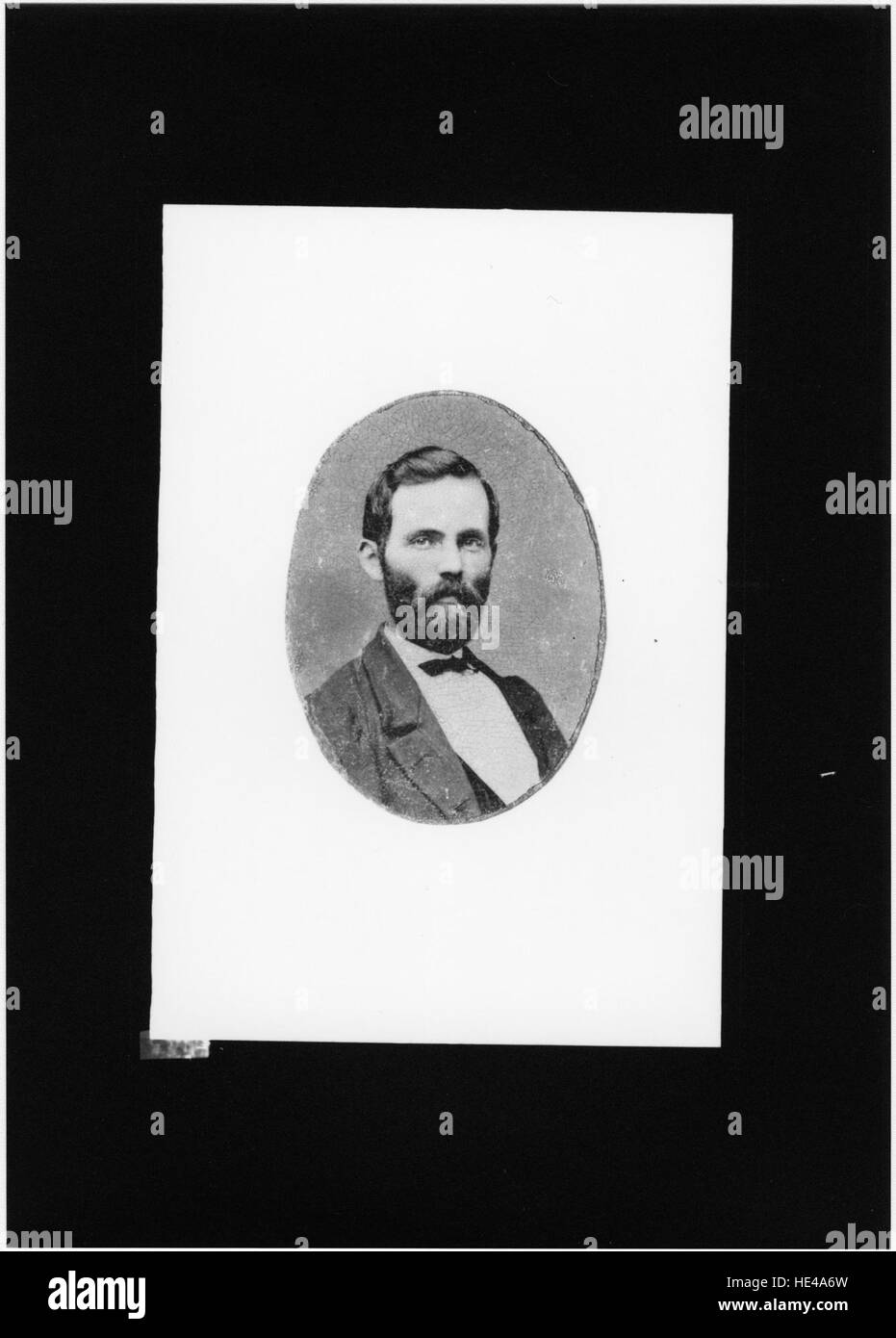 Cette photographie historique capture un homme non identifié, offrant un aperçu des styles et pratiques passés. L'image présente un moment figé dans le temps, mettant en valeur la mode et la culture d'une époque révolue. Banque D'Images