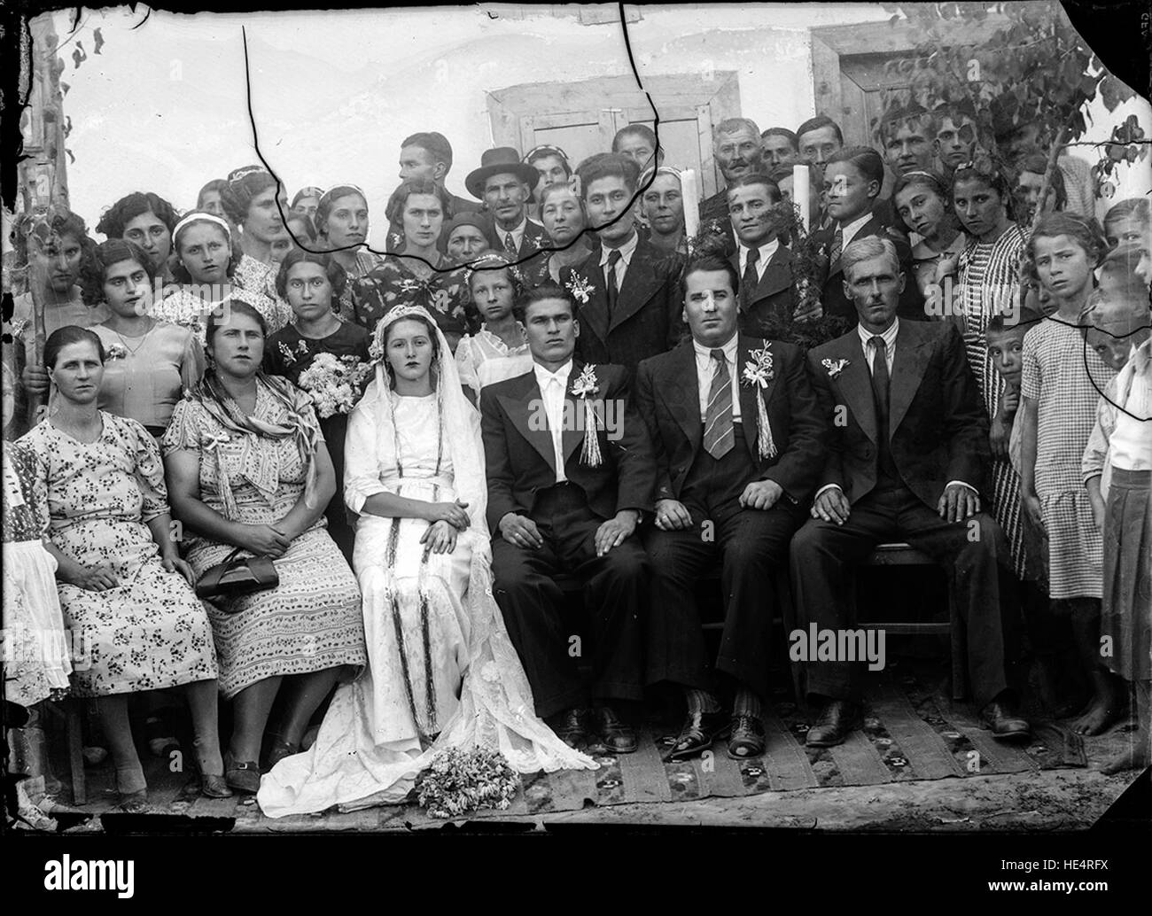 Portrait de mariage des Archives Costică acte, capturé sur une plaque de verre au début du XXe siècle en Roumanie. La photographie en noir et blanc préserve les traditions culturelles roumaines et l'histoire familiale, en mettant l'accent sur les coutumes sociales et les liens familiaux. Banque D'Images