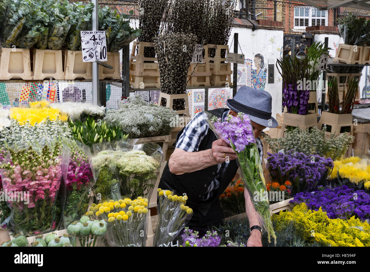 L'homme tend à affichage floral au Columbia Road Flower Markets London Banque D'Images