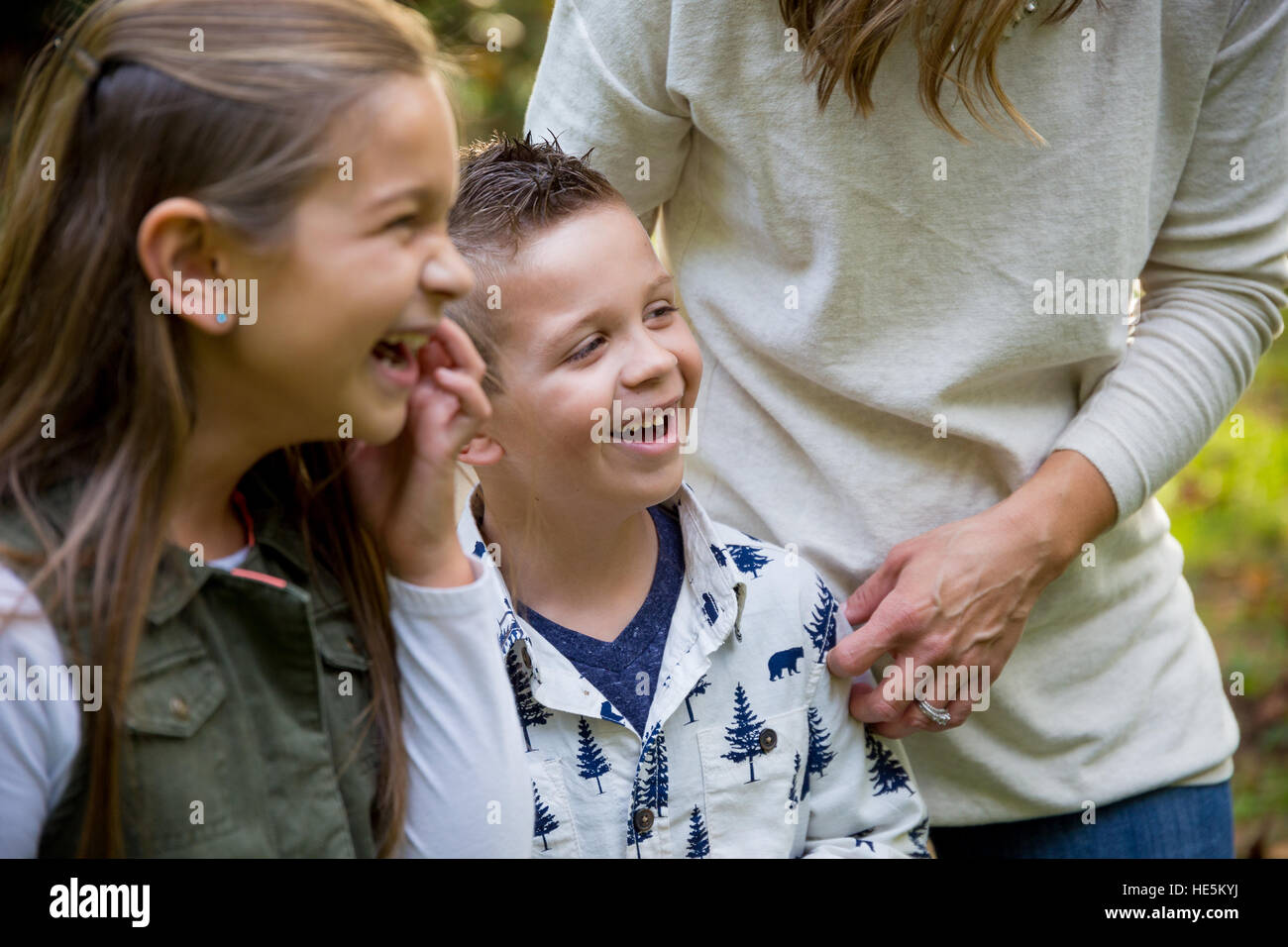 Portrait style candide d'un jeune garçon et sa sœur riant et souriant à un parc naturel. Banque D'Images