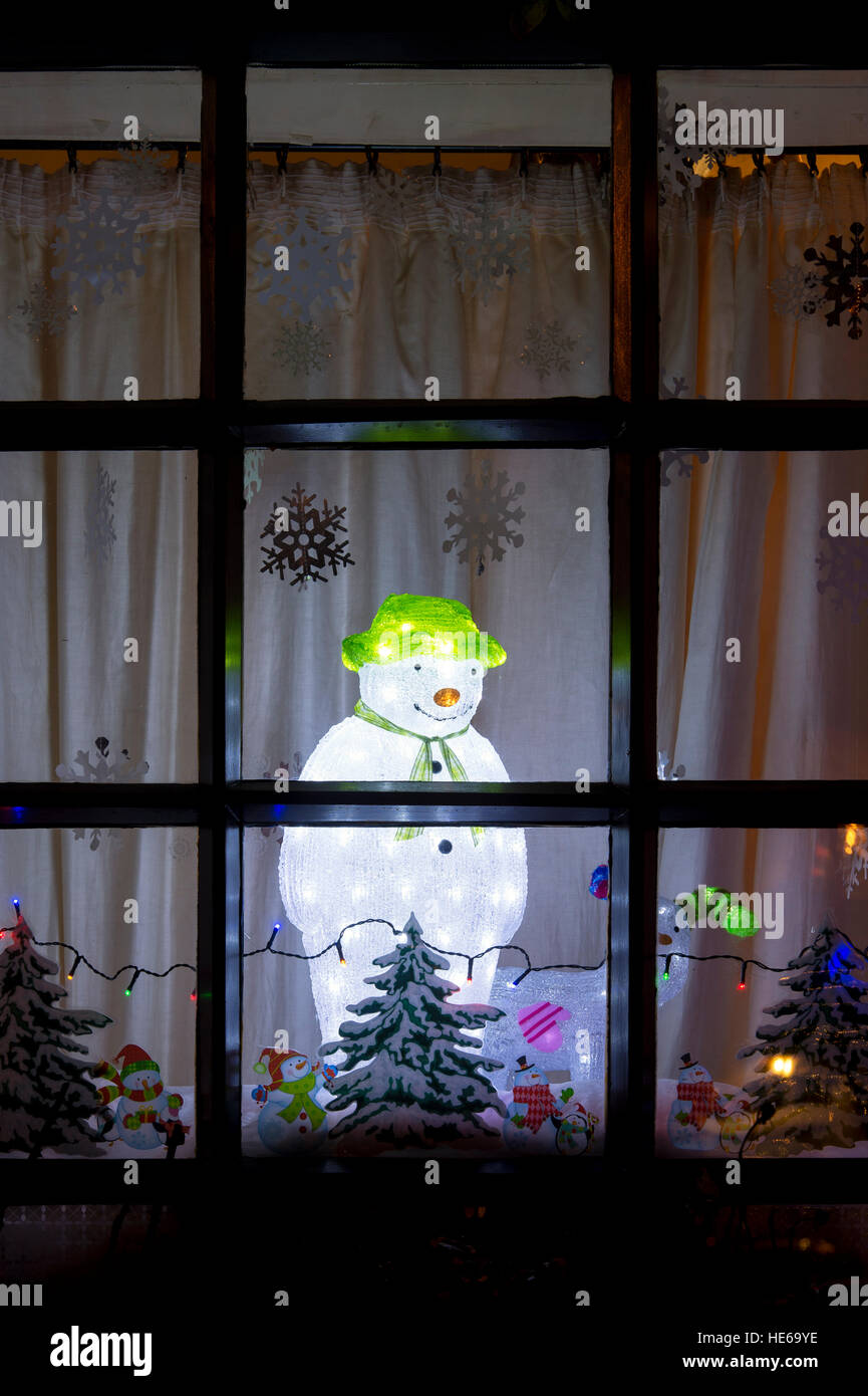 La lumière de Noël Bonhomme de neige décoration dans une fenêtre de la chambre. Deddington, Oxfordshire, Angleterre Banque D'Images