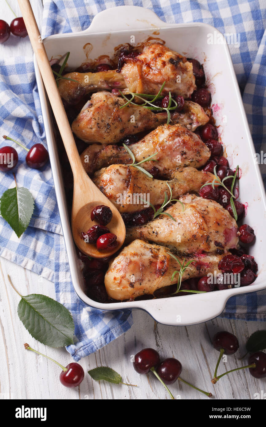 Cuisses de poulet au four à la sauce aux cerises et le romarin dans le plat pour la cuisson de près. La verticale Banque D'Images