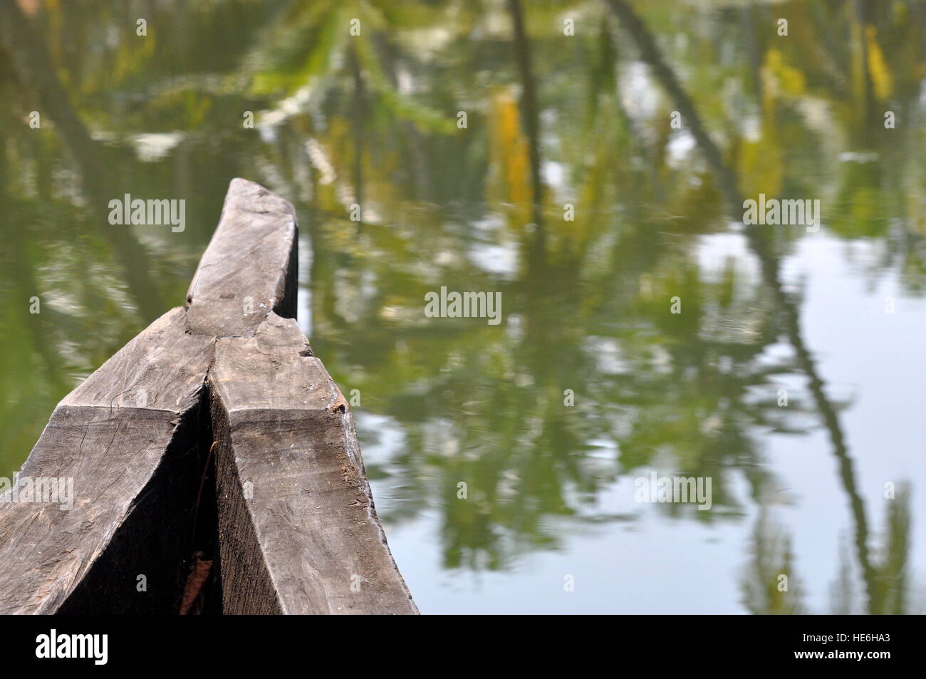 Bateau en bois sur la rivière au Kerala, en Inde et à la réflexion de cocotiers sur l'eau Banque D'Images