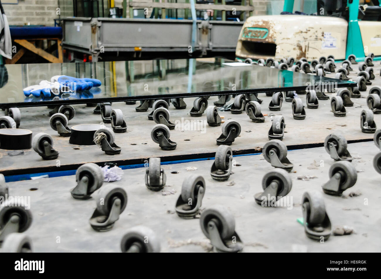 Rouleaux sur une table pour activer le déplacement, la manipulation et la découpe de grandes plaques de verre dans un atelier de découpe de verre. Banque D'Images
