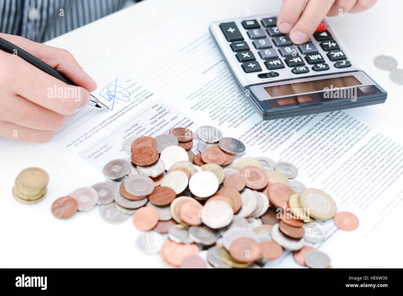 Calcul de l'impôt nouveau ou accord de prêt avec calculatrice de poche et des pièces Banque D'Images