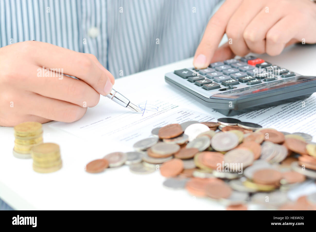 Calcul de l'impôt nouveau ou accord de prêt avec calculatrice de poche et des pièces Banque D'Images