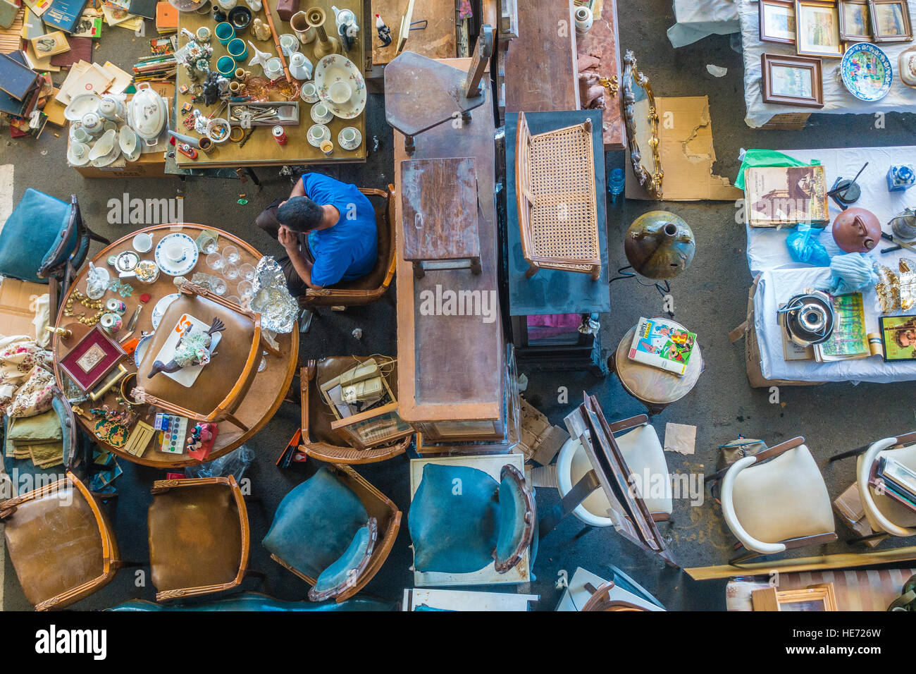 Une vue de dessus d'une brocante à Barcelone, Espagne avec un assortiment éclectique d'articles à vendre et un vendeur masculin. Banque D'Images