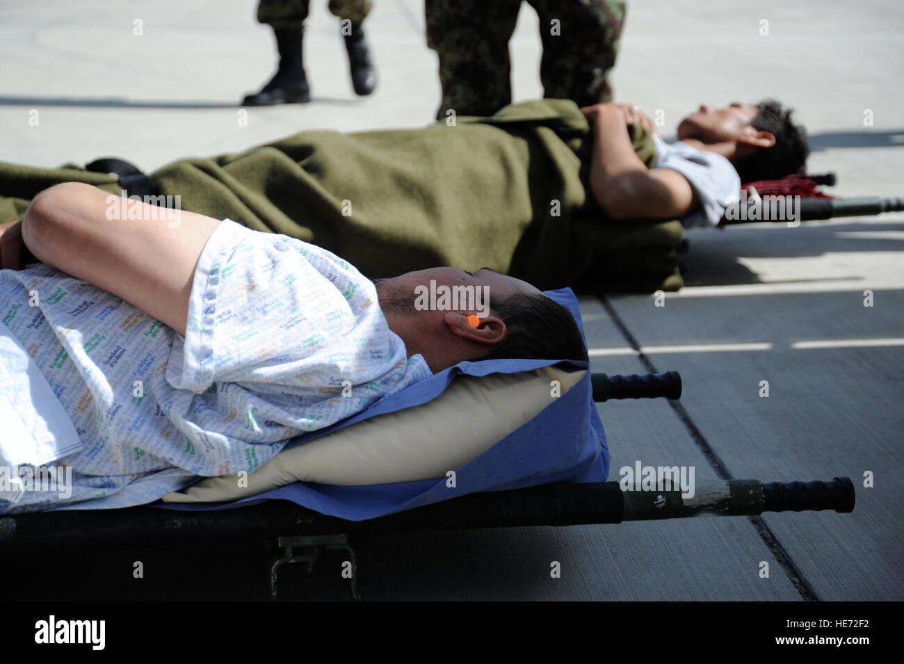 Blessés militaires de l'Armée nationale afghane se trouvent sur des portées en attente de transport par ambulance de l'armée de l'air afghane, Kaboul, Afghanistan, le 20 juillet. Les soldats de l'ANA ont été transportés à partir de Kandahar à Kaboul pour être traités à l'Hôpital Militaire National. Le transfert a été la toute première mission d'évacuation médicale AAF à bord d'un aéronef à voilure fixe. Le s.. Matthew Smith) Banque D'Images