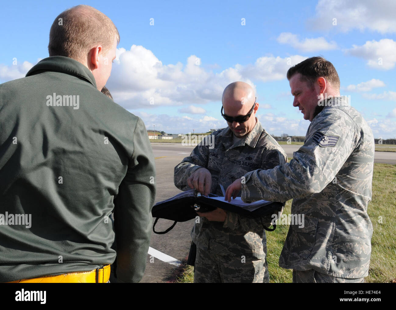 U.S. Air Force Tech. Le Sgt. Shannon Brooks, centre, 100e Escadron de maintenance des aéronefs expeditor production du folio, en Californie, des critiques d'un aéronef cahier des formulaires qui contient des contradictions et des états d'entretien d'aéronefs 19 Février, 2014, le RAF Mildenhall, Angleterre. Brooks amélioré le châssis de lavage programme par l'établissement d'une structure de l'équipe, assurer le transport des équipes de lavage a et des outils adéquats, et il a mis en place un cycle de lavage de 30 jours. Gina Randall Banque D'Images