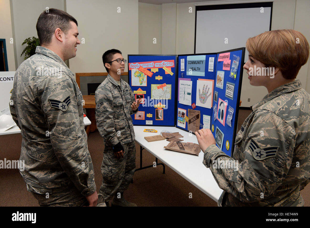Les cadres supérieurs de l'US Air Force Airman Rachel Pavlich, 97e Escadron d'opérations médicales, technicien de la santé publique explique les différentes sections dans le cadre de la santé publique, comme la santé communautaire, la santé au travail, et le déploiement de médicaments pendant le salon de l'emploi au Centre communautaire de la liberté, le 17 mars 2015. Santé communautaire traite de la médecine préventive et des inspections des aliments, de la santé porte sur des dangers, par exemple en veillant à ce que les gens portent leur équipement de protection individuelle et de déploiement du personnel assure la médecine sont médicalement autorisés à déployer. Navigant de première classe Megan E. ACS Banque D'Images