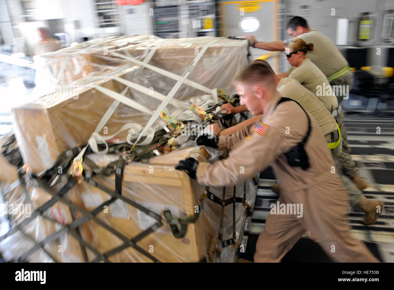 Les arrimeurs et 447e escadron expéditionnaire aérienne Préparation logistique port aviateurs transporter des marchandises d'un C-17 Globemaster III le 10 août 2010, à la base aérienne de Sather, de l'Iraq. Les Aviateurs déchargé 12 palettes de fret, puis reconfigurée à l'avion de transport de passagers en moins d'une heure. Le C-17 est à l'appui du personnel du redéploiement des forces américaines responsables effectifs de forces armées de 50 000 hommes d'ici la fin du mois d'août lors de l'Opération Liberté pour l'Irak se termine, et l'opération aube nouvelle commence. ( Hauts Airman Perry Aston) (publié) Banque D'Images