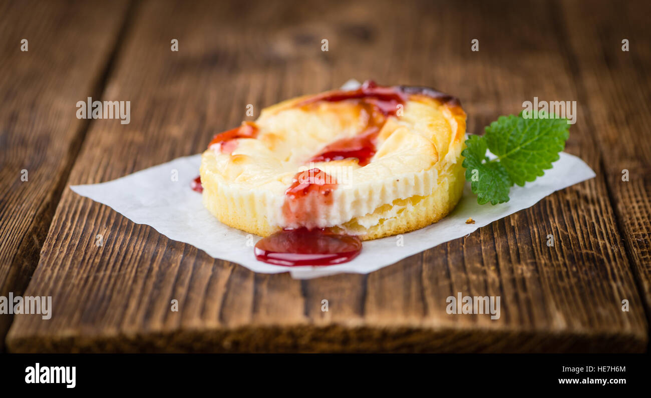 Mini Cheesecake frais (avec la sauce) sur un arrière-plan vintage (gros plan) Banque D'Images