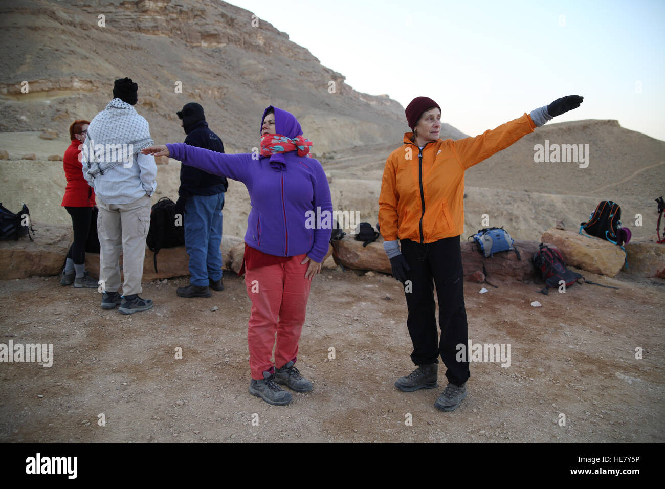 Deux femmes de congélation, randonneurs, tous habillés dans le froid matin font de tai chi à l'aube pour réchauffer avant une randonnée difficile Banque D'Images