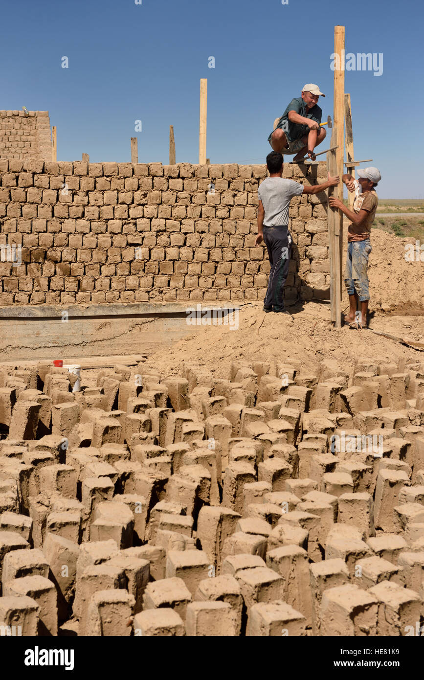 Construction workers building mudbrick maisons dans le développement à l'extérieur du Kazakhstan shymkent Banque D'Images