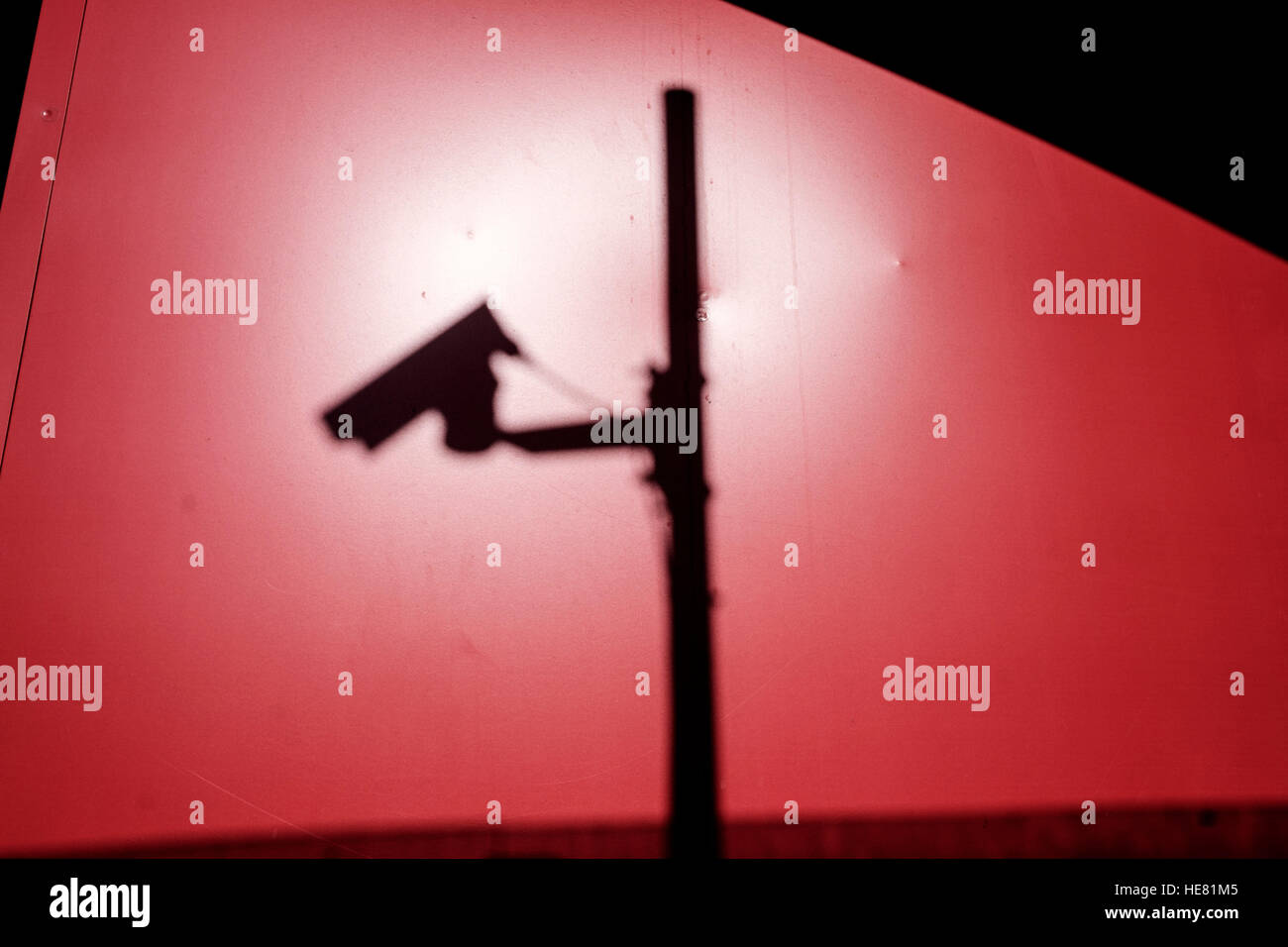 Silhouette d'une caméra de vidéosurveillance sur un fond rouge prises sur une journée ensoleillée Banque D'Images