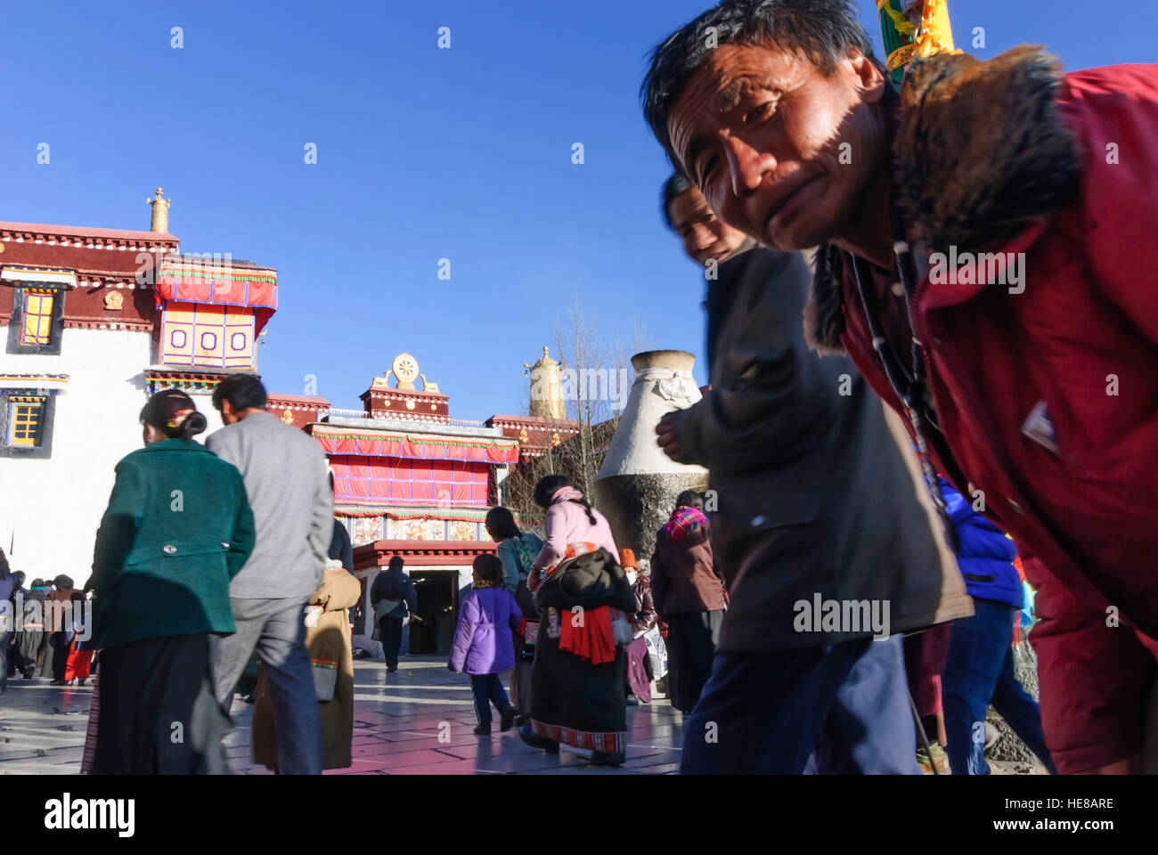 Lhassa : Tibétains le tour du Barkhor (Compostelle) un flagpost (Darchen) devant le Temple de Jokhang, Tibet, Chine Banque D'Images