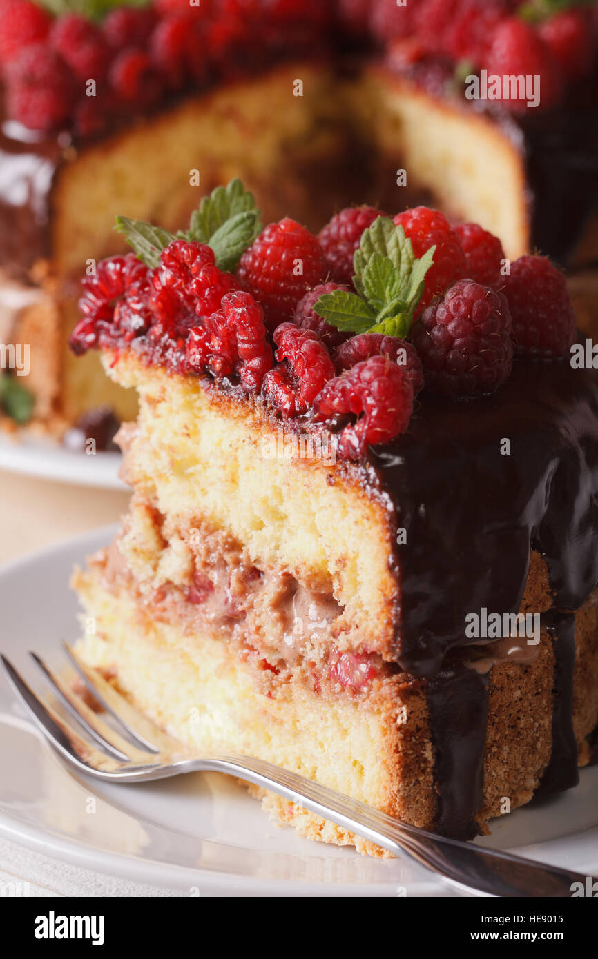 Morceau de gâteau à la framboise avec les baies fraîches macro sur une assiette blanche verticale. Banque D'Images