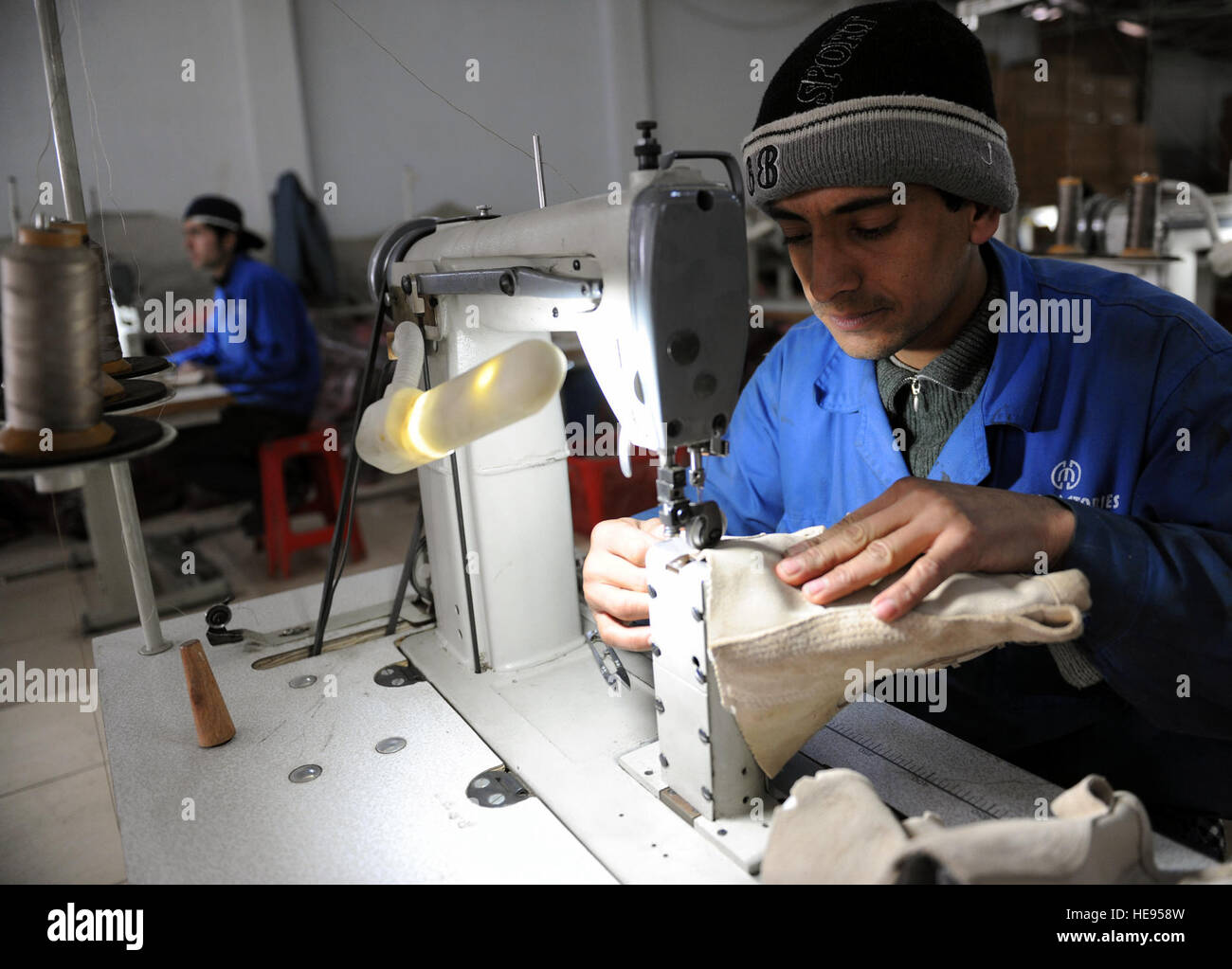 Un employé d'usine Milli Kaboul semer un ensemble d'amorçage lors du démarrage du processus de fabrication à Kaboul, Afghanistan, le 18 janvier 2010. Membres du CSTC-A et l'Armée nationale afghane a visité l'usine de fabrication de bottes pour observer le processus de fabrication et d'amorçage pour lancer un programme d'amélioration de processus. (U.S. Air Force Photo/Le s.. Larry E. Reid Jr., sorti) Banque D'Images