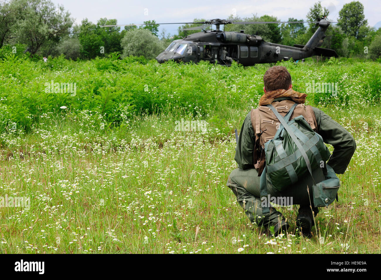 U.S. Air Force Le Capitaine William Flynt, un F-16 Fighting Falcon pilote avion avec le 555e Escadron de chasse, attend d'approcher une armée UH-60 Black Hawk lors d'un de recherche et sauvetage de combat mission de formation le 24 juin 2014, au terrain d'entraînement près de Meduna Cellina Maniago, Italie. La formation dispensée aux aviateurs à éviter la capture des compétences de survie en attendant d'être récupérés. Navigant de première classe Ryan Conroy Banque D'Images