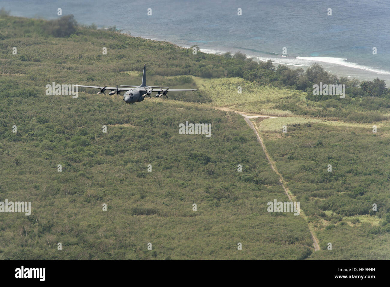 Un U.S. Air Force C-130H Hercules vole au-dessus de North Field, Tinian, Marianna Îles, au cours de faire face Nord 15, 26 février 2015. Champ du nord a servi de la Deuxième Guerre mondiale, l'administration centrale pour le 509e groupe composite qui a lancé la bombe atomique contre Hiroshima et Nagasaki, au Japon, en août 1945. Par le biais de la formation des exercices tels que l'exercice physique Faire Face Nord 15, les États-Unis, le Japon et l'Australie, les forces de l'air développer les capacités de combat, l'amélioration de la supériorité aérienne, la guerre électronique, de l'interdiction aérienne, le transport aérien tactique et aerial refueling. Tech. Le Sgt. Jason Robertson Banque D'Images